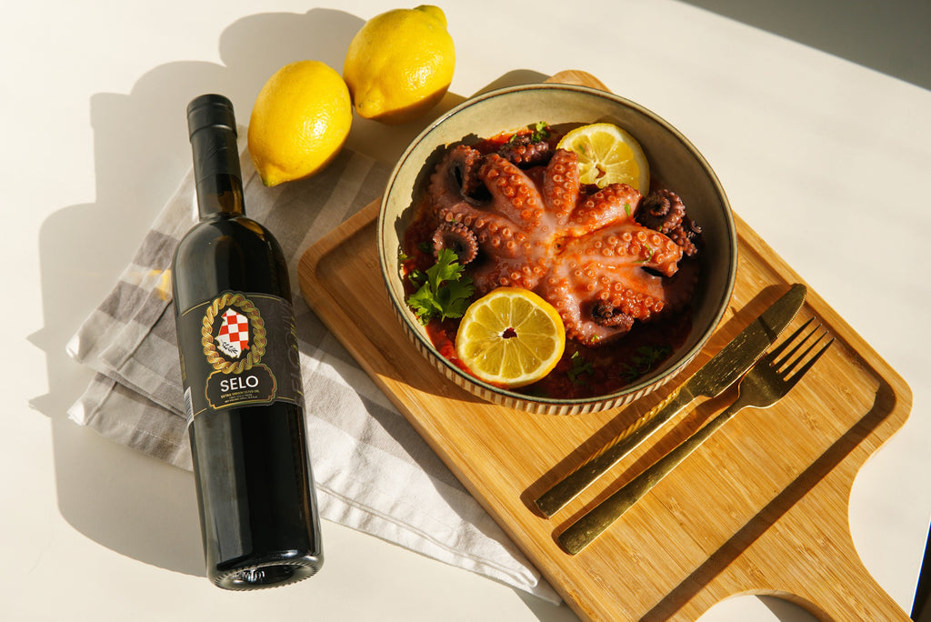 Tender Sauce Pan Octopus cooked to perfection, glistening with Croatian olive oil and garnished with fresh herbs, showcasing a delectable seafood dish.