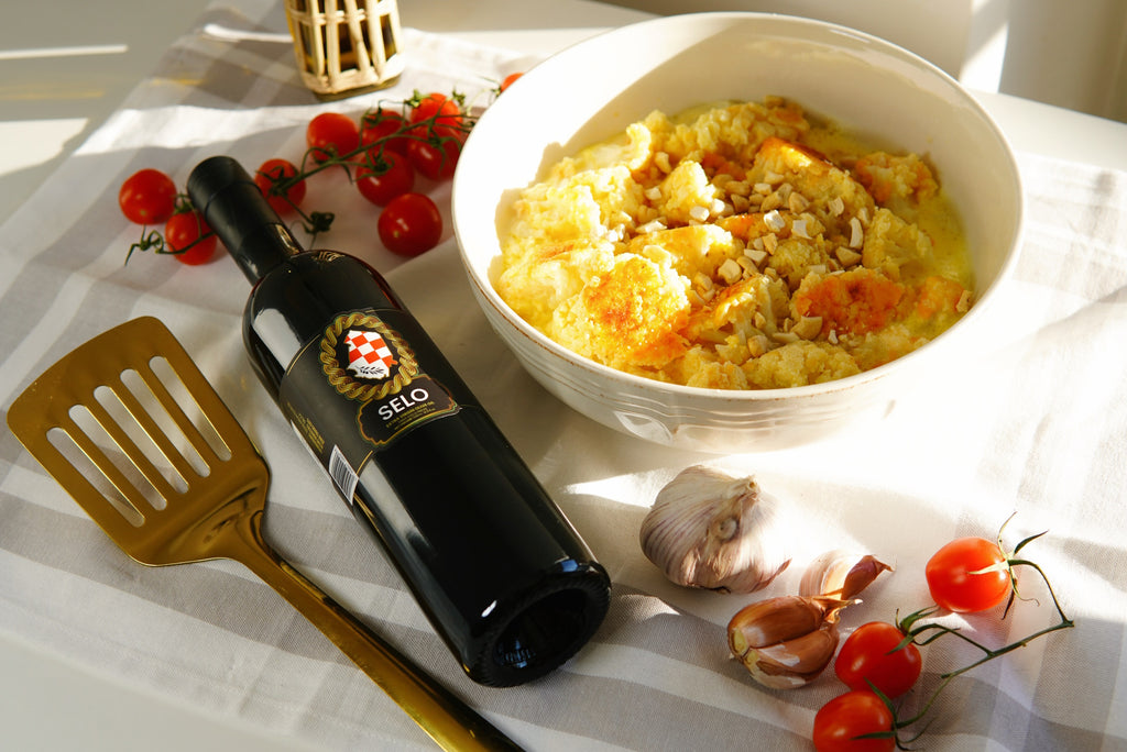 A golden Cauliflower Casserole (Čušpajz od Karfiola) baked to perfection and drizzled with Croatian olive oil, showcasing a flavorful and healthy side dish.